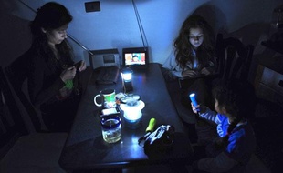 Une famille s'éclaire à la lanterne durant la coupure d'électricité du 24 septembre 2011