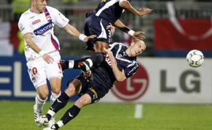 Olympique Lyon's Karim Benzema (L) challenges Enrique (C) and Mathieu Chalme (R) of Bordeaux during their French Ligue 1 soccer match at the Gerland stadium in Lyon March 9, 2008. REUTERS/Robert Pratta