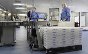 Des employés travaillent à la société pharmaceutique Pfizer lors d'une visite officielle de la présidente de la Commission européenne, Ursula von der Leyen, à Puurs, en Belgique, le vendredi 23 avril 2021.
