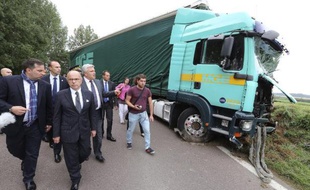 Le ministre de l'Intérieur Bernard Cazeneuve (3e à gauche) et le ministre des Transports Frédéric Cuvillier (4e à gauche) devant l'épave du poids-lourds après sa collision avec un minibus, près de Troyes le 22 juillet 2014