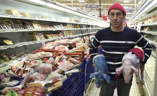 Un éleveur avec deux porcelets lors d'une opération coup-de-poing au supermarché Cora à Pacé, près de Rennes.