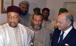 Le président du Niger Mahamadou Issoufou accompagné de Laurent Fabius et des otages français d'Arlit (dont Thierry Dol et François Larribe, au centre) le 29 octobre 2013 à l'aéroport de Niamey.