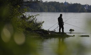 Un pêcheur au bord d'un lac. Illustration.