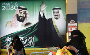 Deux femmes passent devant des portraits du roi Salman et du prince Mohammed ben Salman, le 5 février, à Djeddah, en Arabie saoudite.