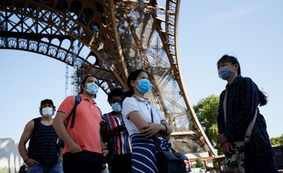 Des touristes au pied de la Tour Eiffel après plusieurs semaines de fermeture à cause de la pandémie de coronavirus.