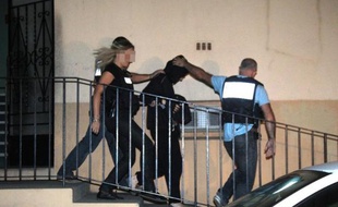 Cécile Bourgeon (C), placée en détention provisoire, est escortée par des policiers le 25 septembre 2013 à Perpignan