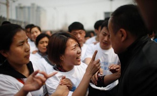 Des proches des victimes du vol MH370 manifestent leur colère, à Pékin le 25 mars 2014