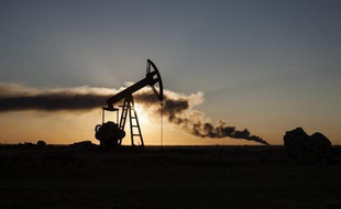 De la fumée s'élève des décombres d'une raffinerie de pétrole près de la ville syrienne de Ramlan, le 20 octobre 2013