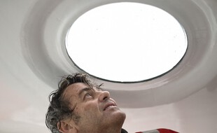 French skipper Yannick Bestaven looks out a porthole as he sails his Imoca 60 monohull 'Maitre Coq' on October 7, 2020, in the Atlantic ocean off the coast of La Rochelle, western France, a few weeks prior to take the start of the Vendee Globe round-the-world solo sailing race. - The 2020 edition of the Vendee Globe begins on November 8, 2020. (Photo by Sebastien SALOM-GOMIS / AFP)