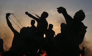 Des manifestants palestiniens jettent des pierre aux soldats israéliens lord d'affrontements à Gaza le 13 octobre 2015.