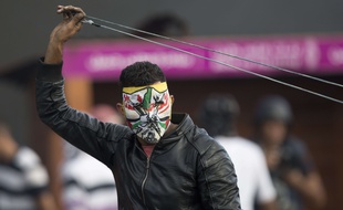 Un palestinien masque se prépare à lance rune pierre avec une fronde à Ramallah, le 9 octobre 2015