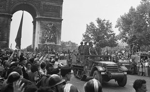 Le half-track Guernica de la Nueve (véhicule blindé avec des chenilles à l'arrière) descend les Champs-Elysées après la libération de Paris, le 26 août 1944.