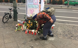 Une femmes déposes des fleurs en hommages aux victimes contre l'attentat de Berlin le 20 décembre 2016.