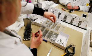 Une femme employée de l'usine Remade de Poilley travaille sur un téléphone reconditionné.