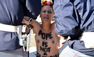 A topless Femen activist is arrested as she protests with other Femen in St Peter's square on November 14, 2013 at the Vatican. They protest against the Pope's planned visit at EU parliament as an attack on secularism. AFP PHOTO / ALBERTO PIZZOLI