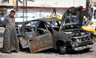 Inspection d'une voiture piégée à Bagdad, en Irak, après une attaque le 3 juillet 2013.