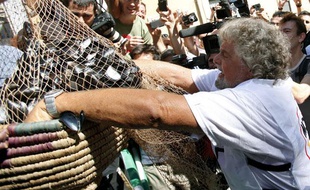 Le comédien Beppe Grillo déverse des moules devant le Parlement italien pour protester contre le plan d'austérité, le 10 septembre 2011.