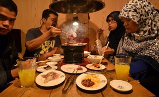 Des touristes thaïlandais musulmans dégustent des mets certifiés halal dans un restaurant de Tokyo, le 24 juin 2014
