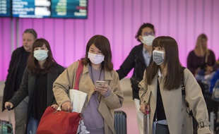 Des passagers masqués arrivent à l'aéroport de Los Angeles, en Californie, le 22 janvier 2020.