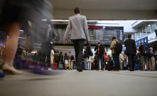 Des passagers à la Gare Montparnasse le 20 juin 2014, regardent le tableau d'affichage alors que la grève des cheminots affecte la circulation des trains