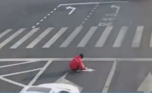 La police a trouvé ce Chinois accroupi sur la chaussée, au milieu d'un vaste carrefour, avec un petit pot de peinture à côté de lui