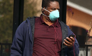 Un homme portant un masque attend le bus à San Francisco, le 15 novembre 2018.