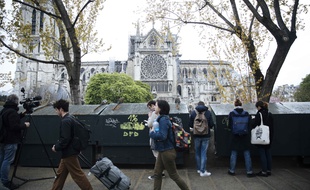 Passants devant Notre-Dame de Paris au lendemain de son incendie du 15 avril 2019