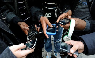 Des jeunes utilisent leur téléphone portable