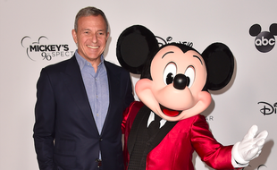 Bob Iger, PDG de la Walt Disney Company, au côté d'un comédien incarnant Mickey Mouse, lors d'une soirée de gala, en octobre 2018.