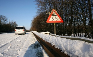Un panneau de signalisation de zone de verglas lors d'un jour de neige. (Illustration).