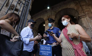 Les touristes font vérifier leur pass sanitaire, green pass, par le personnel de sécurité à l'entrée du Colisée à Rome, en Italie, le vendredi 6 août 2021.