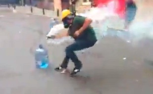 Un manifestant turc maîtrisant une grenage lacrymogène, le 17 juin 2013.