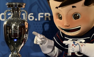 Super Victor, la mascotte de l'Euro 2016, pose à côté du trophée, le 12 mai 2015, à Paris.