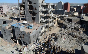 Des gens marchent dans les ruines de la ville kurde de Cirze, dans le sud-est de la Turquie, dévastée par des affrontements entre les kurdes et l'armée turque