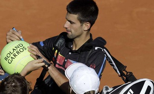 Le Serbe Novak Djokovic signe des autographes à la fin de son match contre Victor Hanescu, le 25 mai 2011 à Roland-Garros.