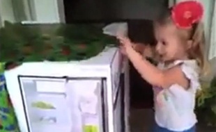Capture d'écran d'une vidéo montrant une fillette découvrir son papa militaire, de retour d'Afghanistan, caché dans son cadeau d'anniversaire.