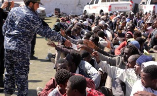 Des migrants de l'Afrique sous-saharienne reçoivent à boire le 17 mai 2015 dans un centre de détention de Tripoli, en Libye, après avoir été arrêtés alors qu'ils tentaient de traverser la Méditerranée à bord de bateaux de passeurs illégaux