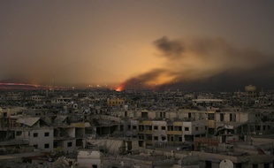 De la lumière et de la fumée sur le quartier de la Ghouta orientale en Syrie, le 11 mars 2018.
