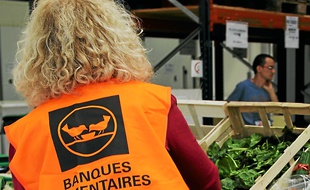 Une bénévole trie les denrées, lundi.