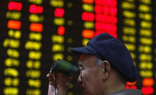 Un homme suit les cours de la Bourse à la jumelle, dans la province du Hubei, en Chine, le 28 mars 2008.