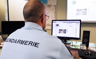 Illustration. Un gendarme devant un ordinateur