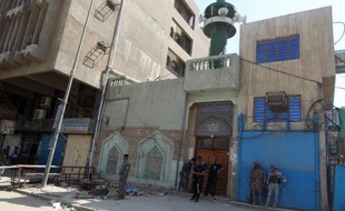 Des policiers irakiens inspectent le 27 mai 2014 les lieux d'un attentat à la bombe qui a fait 13 morts à l'extérieur d'une mosquée chiite à Bagdad