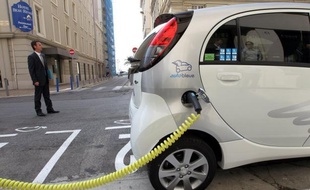 Un véhicule électrique à une borne de recharge.