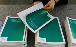 Un bénévole feuillette le rapport de la commission d'enquête allemande sur la collection Gurlitt, avant une conférence de presse à Berlin, le 14 janvier 2016.
