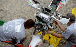 Des mécaniciens au travail sur une moto lors du Dakar 2013.