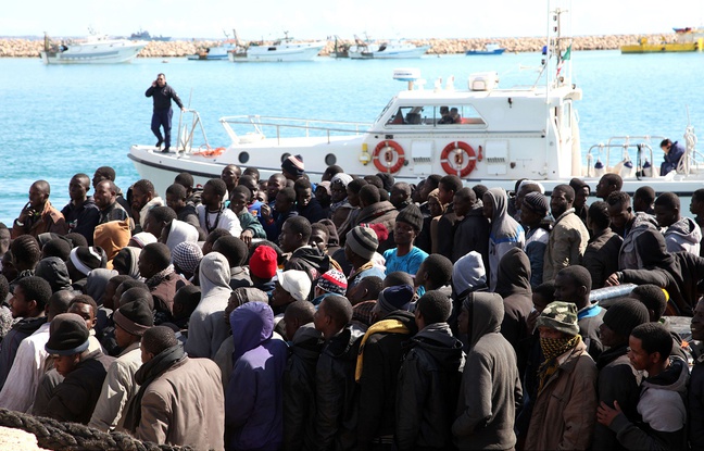 Des migrants en provenance de Libye, secourus par la marine italienne, débarquent en Sicile le 15 février 2015. Des migrants en provenance de Libye, secourus par la marine italienne, débarquent en Sicile le 15 février 2015.