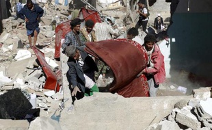 Des Yéménites récupèrent des biens des débris des maisons détruites par les raids aériens conduits par l'Arabie saoudite, le 1er mai 2015 à Sanaa, la capitale du pays