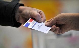 Un électeur présente sa carte électorale à un scrutateur