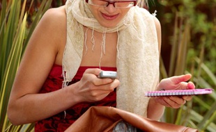 Une jeune femme en train d'envoyer un SMS.