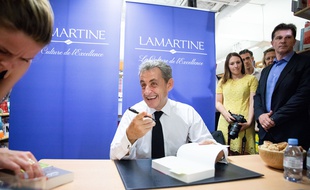 L'ancien président Nicolas Sarkozy signe des exemplaires de son nouveau livre lors d'une séance de dédicace de son nouveau livre à la librairie Lamartine, le 28 juin 2019.